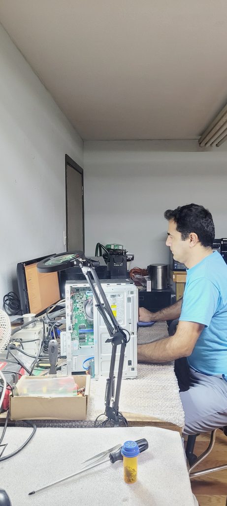 Technician upgrading a computer hard drive at a repair shop in Houston.