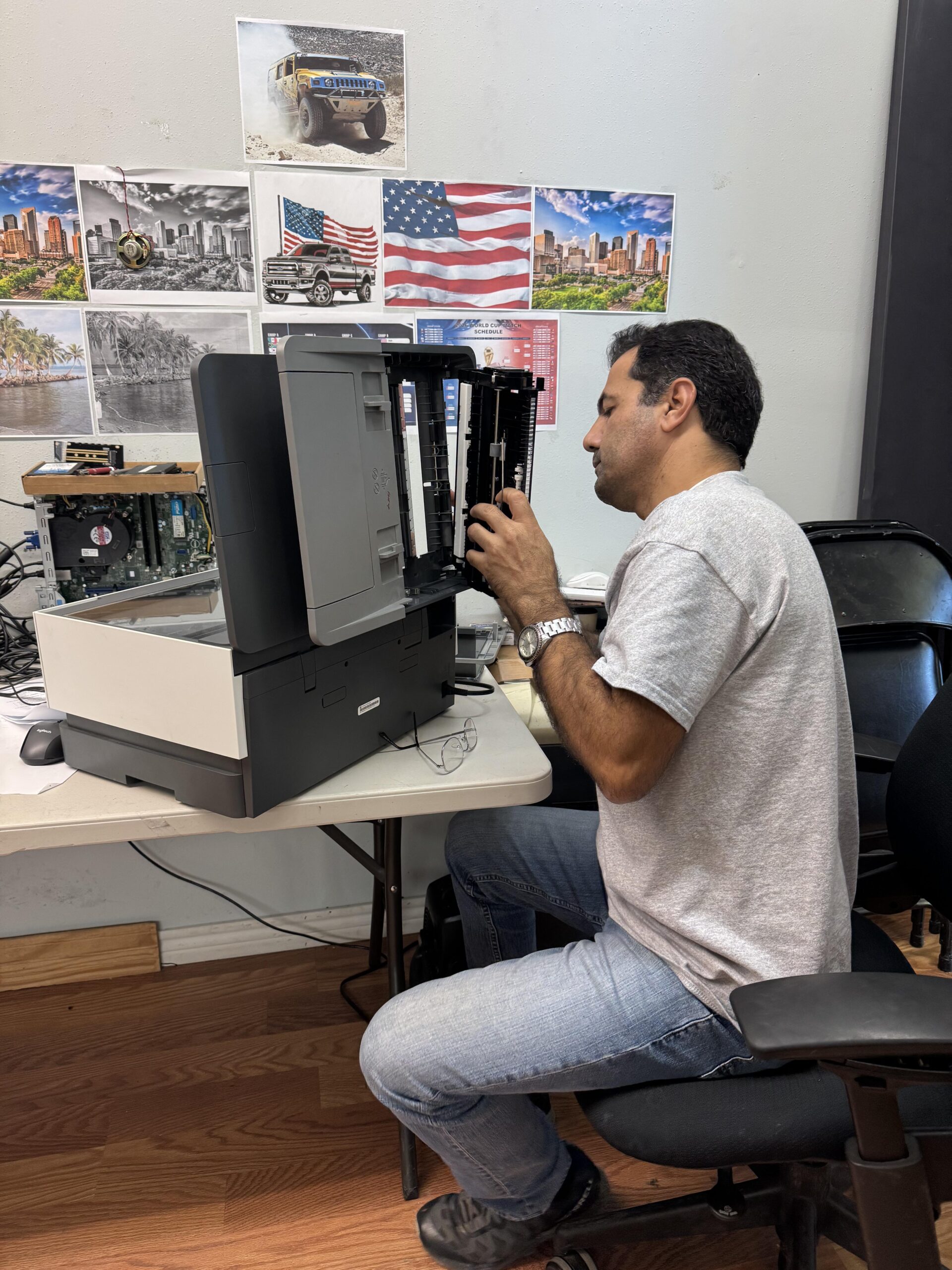 Technician repairing a printer during diagnostics and hardware troubleshooting.